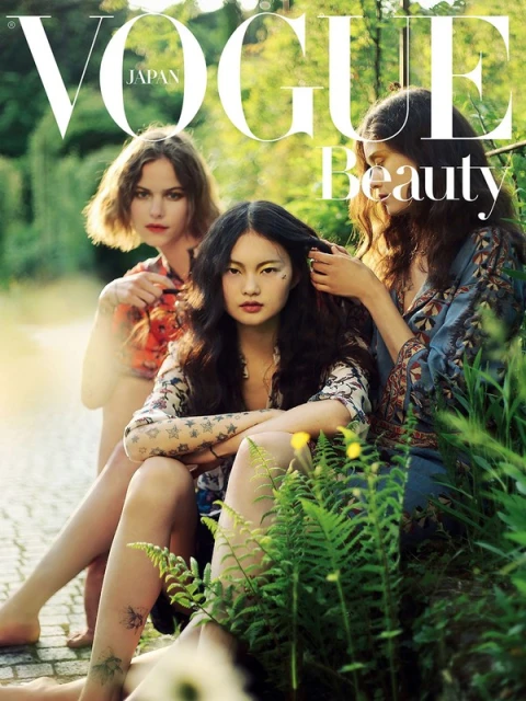 Vogue Japan beauty editorial featuring three women with natural makeup and floral-patterned clothing in a lush outdoor setting.
