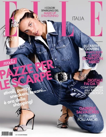 Elle Italia magazine cover featuring a posing fashion model in denim jumpsuit and embellished high-heeled sandals in a studio setting.