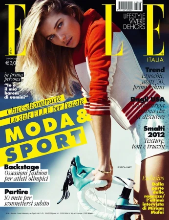 Magazine cover featuring a blonde woman leaning on bicycle handlebars wearing a red white and blue athletic top