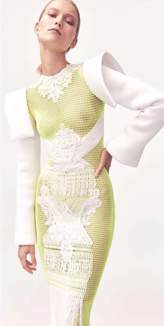 Blonde fashion model wears fitted white and green dress in a bright studio. Fashion, beauty and portrait photography.
