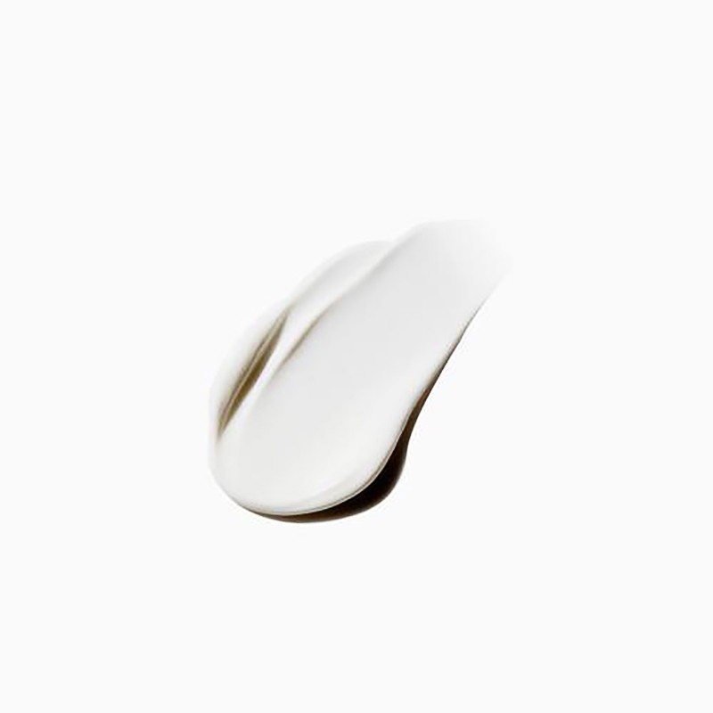Close-up of a smear of white cream against a bright white background, showcasing the texture and consistency of the product.