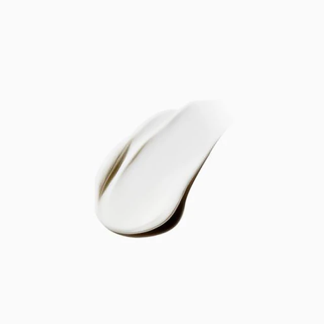 Close-up of a smear of white cream against a bright white background, showcasing the texture and consistency of the product.