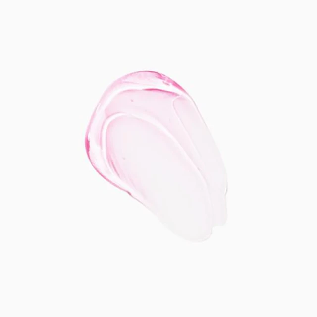 Close-up shot of a clear gel-like beauty product smear with a pink tint on a white backdrop, ideal for showcasing skincare textures.