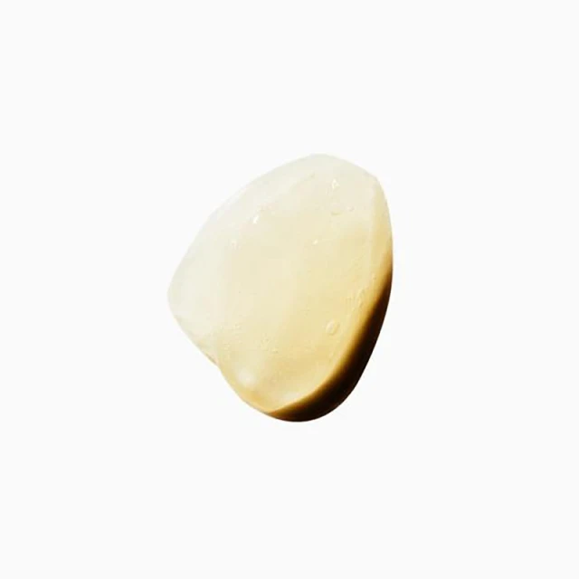 Close-up studio shot of translucent amber gel serum blob, highlighting texture and color on a white background for beauty product marketing.