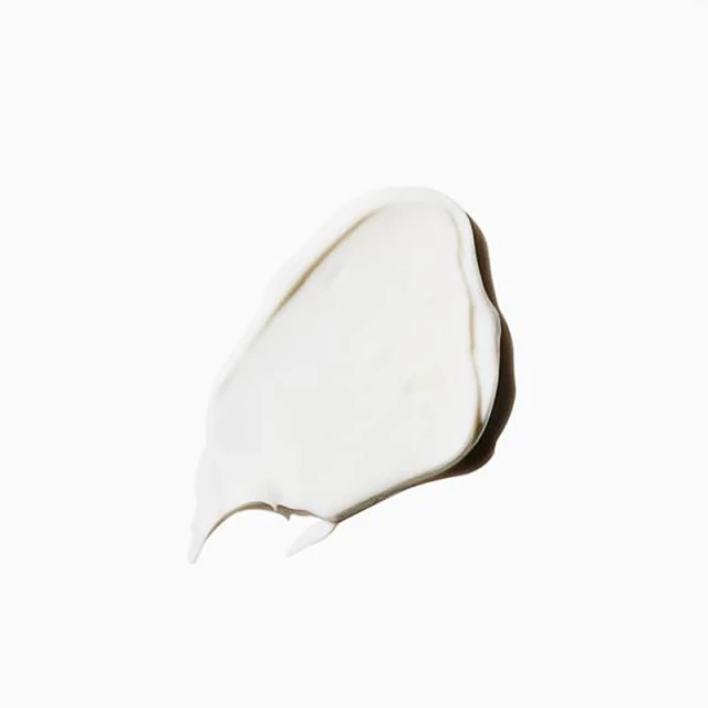 Close-up of a dollop of white cream or lotion on a white background, showcasing its smooth texture and light-reflecting qualities.