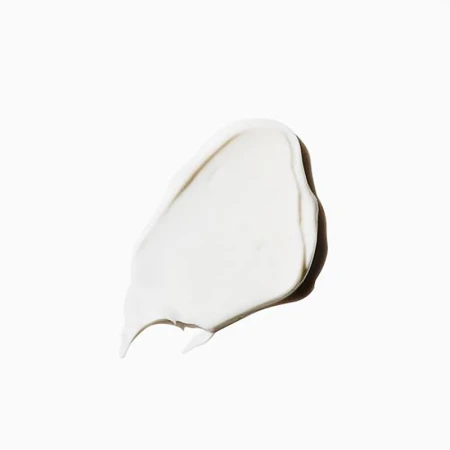 Close-up of a dollop of white cream or lotion on a white background, showcasing its smooth texture and light-reflecting qualities.