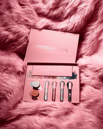 Cosmetic set on a fluffy surface featuring blush, eyeshadow, and lip gloss in pink and silver tones, ideal for beauty product promotions.