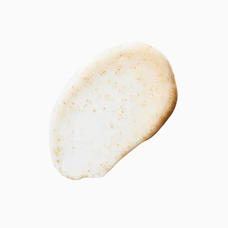 Swirl of skincare cream on a white surface with speckles, highlighting texture and consistency for beauty product promotion.