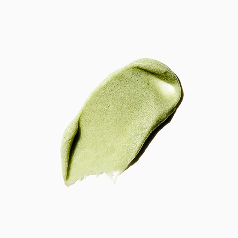 Close-up of a textured smear of light green cosmetic product on a white surface, perfect for beauty and skincare promotions.