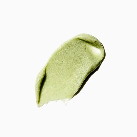Close-up of a textured smear of light green cosmetic product on a white surface, perfect for beauty and skincare promotions.