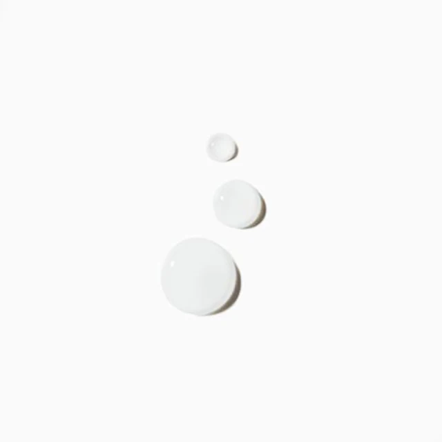 Three drops of translucent liquid are arranged on a bright white surface with subtle shadows underneath each drop.