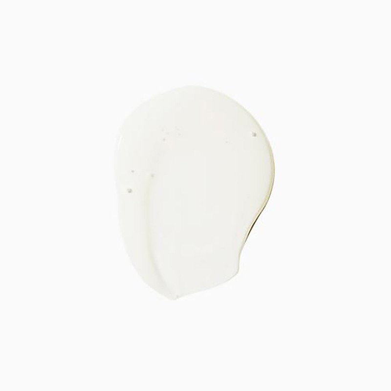 Close-up of an off-white cosmetic cream smear on a bright white background, with smooth textures and subtle shadows.