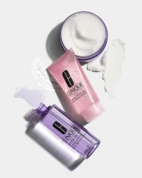 Top-down view of Clinique skincare products including a jar of cream, a pink gel tube, and a purple liquid bottle on white.