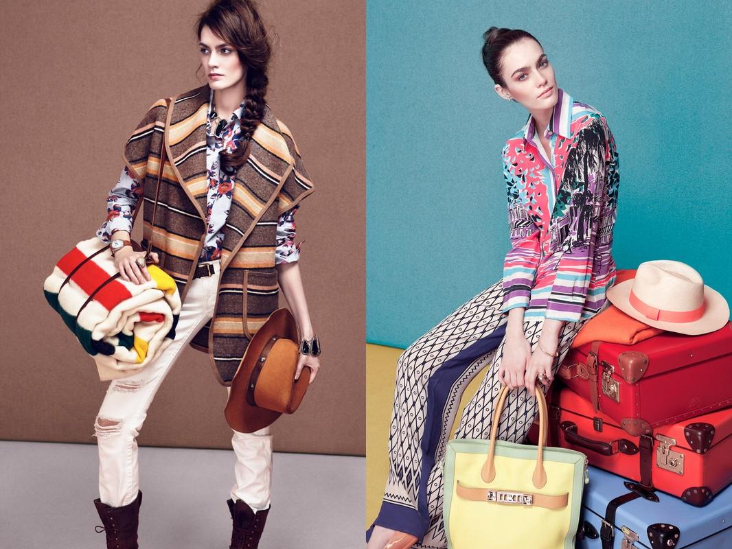 Two fashion models pose wearing patterned shirts, vests, and pants, with colorful blankets, handbags and suitcases in a studio setting.