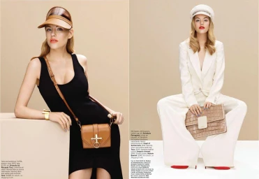Two fashion models posing against a neutral backdrop, one in a black dress with a brown visor and crossbody bag, one in a white suit with a cap.