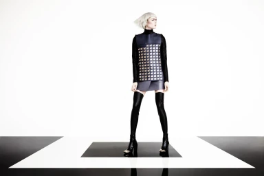 Model with silver bob haircut wearing dark graphic tunic and thigh-high boots in studio by Andrea Huelse