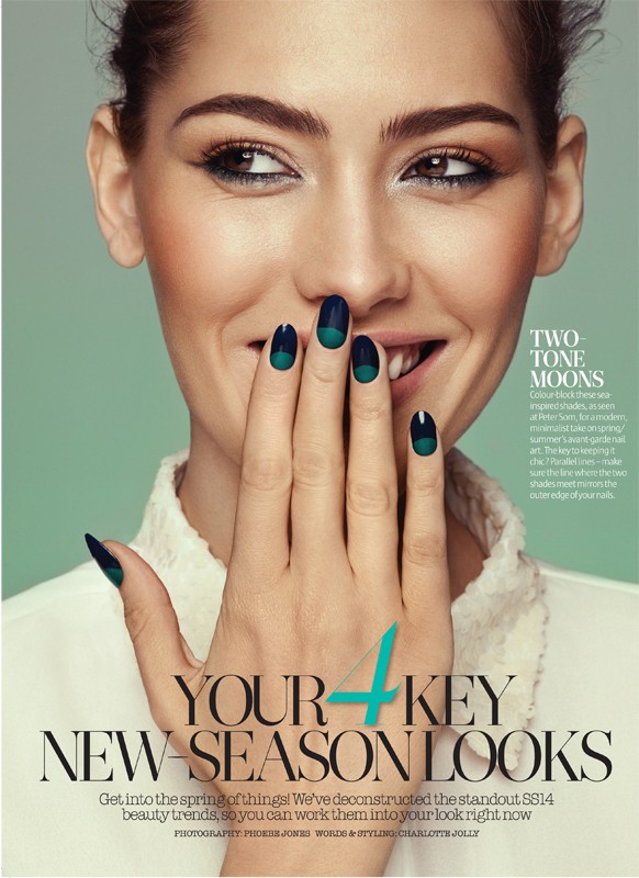 Close-up beauty shot of a woman with green-and-black two-tone nail art, smiling with her hand partially covering her mouth.