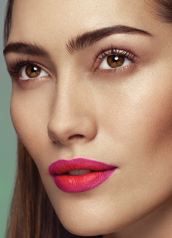 Close up portrait of a woman featuring vibrant hot pink and red gradient lipstick and defined brows