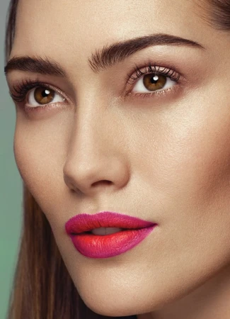 Close up portrait of a woman featuring vibrant hot pink and red gradient lipstick and defined brows