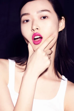 Close-up beauty portrait of an East Asian woman with bright pink lipstick wearing a white tank top