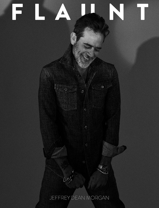 Black and white portrait of Jeffrey Dean Morgan wearing a denim jacket with a smile, in front of a dark gray background with 'Flaunt' text.