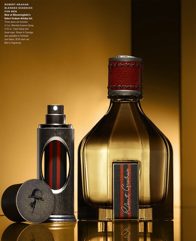 Robert Graham fragrance set on a reflective gold surface against a gold background, featuring cologne and travel spray.
