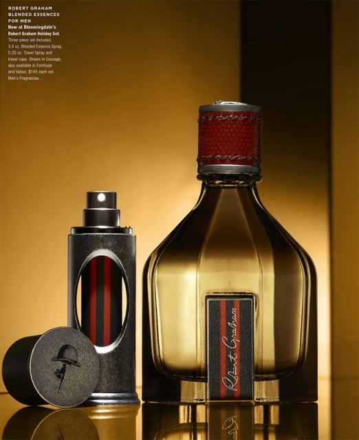 Robert Graham fragrance set on a reflective gold surface against a gold background, featuring cologne and travel spray.