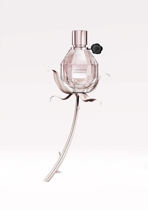 Close-up of a perfume bottle by Viktor & Rolf, in a flower-shaped metal holder, set against a white background. Beauty and fragrance concept.
