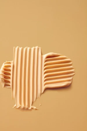 Beige cosmetic cream swatch with combed ridges on a matching beige background styled by Beverley Hyde