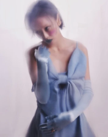 Model with motion blur wearing a light blue dress and matching opera gloves styled by Bobette Cohn