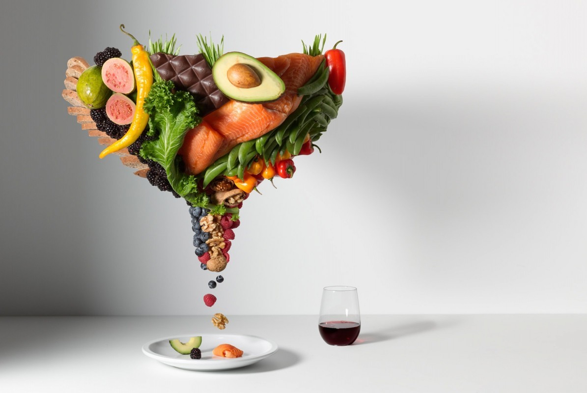 Conceptual studio shot of fruits, vegetables, salmon, chocolate, nuts, berries, and wine, representing healthy eating and a balanced diet.