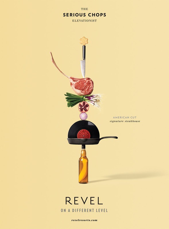 Creative food photography featuring a tomahawk steak, vegetables, frying pan, and bottle stacked on a pale yellow background.