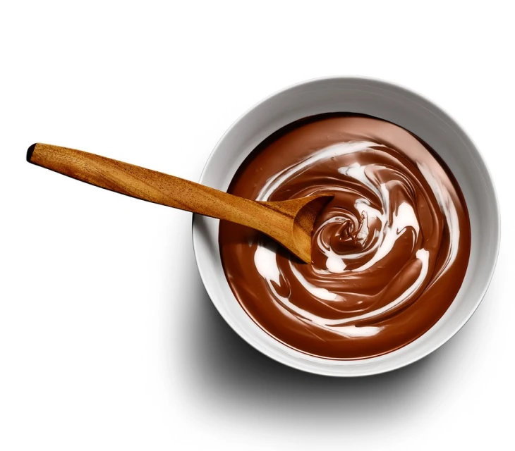 Overhead shot of a wooden spoon in a white bowl filled with a creamy chocolate swirl, on a white background, studio lighting.