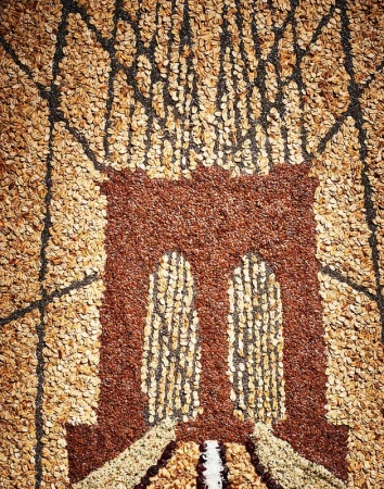 An intricate food art mosaic depicting the Brooklyn Bridge made entirely from various grains, seeds, and oats by Brett Kurzweil.
