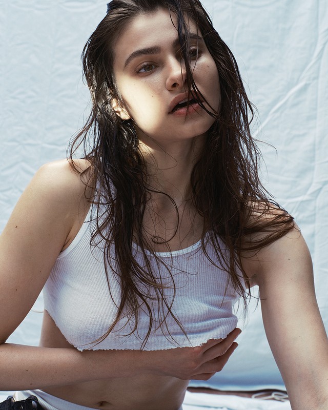 Wet-haired woman wearing a white ribbed tank top against a textured white backdrop by photographer Brooke Nipar