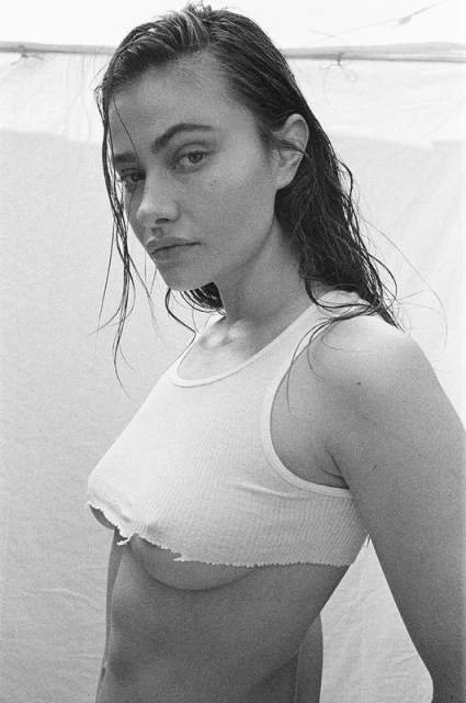 Black and white portrait of a woman with wet hair wearing a tank top against a neutral background. Close-up shot with soft lighting.