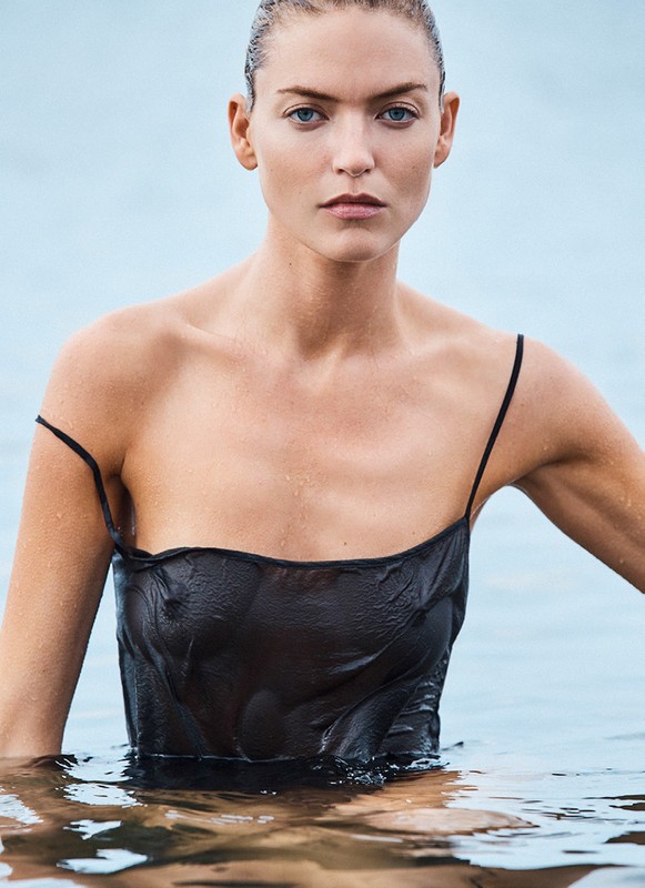 Close-up portrait of a woman with wet hair wearing a black slip dress submerged in water