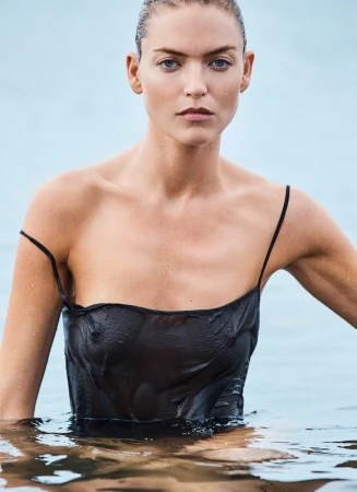 Close-up portrait of a woman with wet hair wearing a black slip dress submerged in water