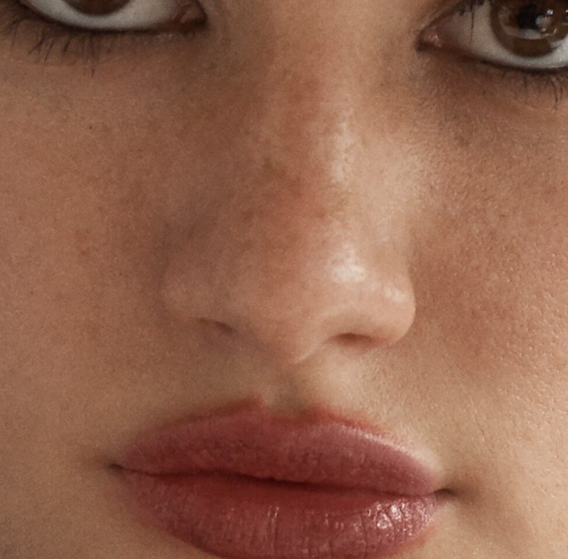 Close-up beauty portrait focusing on eyes, freckled nose, and glossy lips styled by Campbell Ritchie