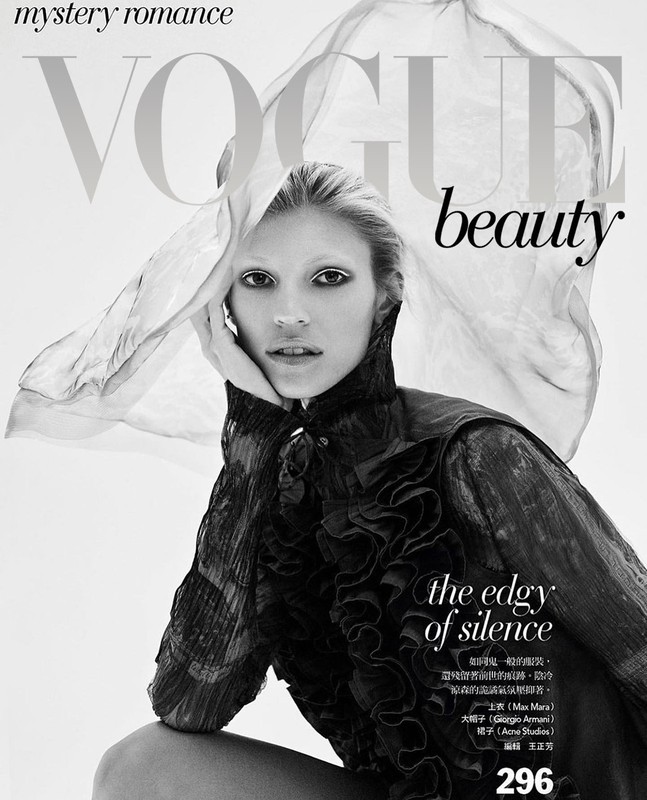 Fashion magazine cover featuring a fair-skinned model in a ruffled black top with dramatic white eye makeup, set against a light background.