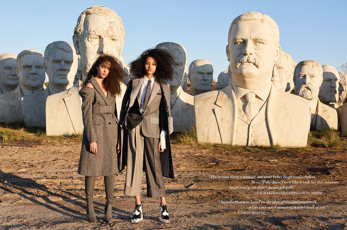 Two female models posing outdoors in front of giant presidential bust sculptures with warm sunlight.