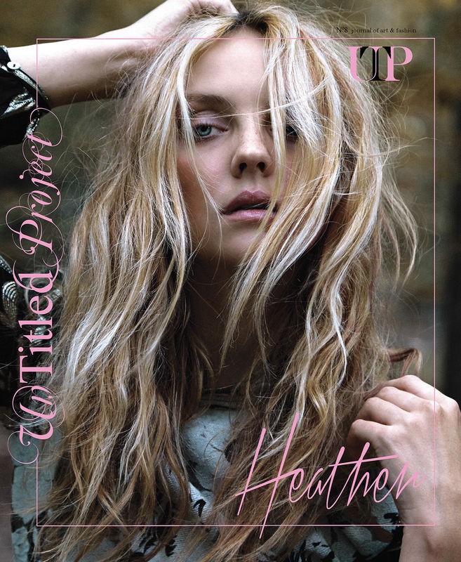 Portrait of a young fair-skinned woman with blonde hair and blue eyes, against a blurred outdoor background for a magazine cover.