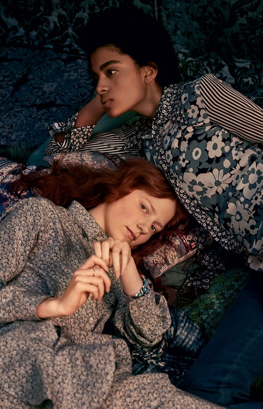 Two women in vintage-inspired floral dresses pose while lying down. The aesthetic evokes a nostalgic, vintage fashion editorial.