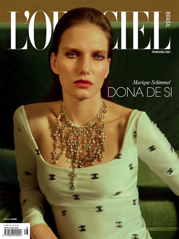 Magazine cover featuring a woman with dark hair, fair skin, and a pearl necklace wearing a white top with black Chanel logos.