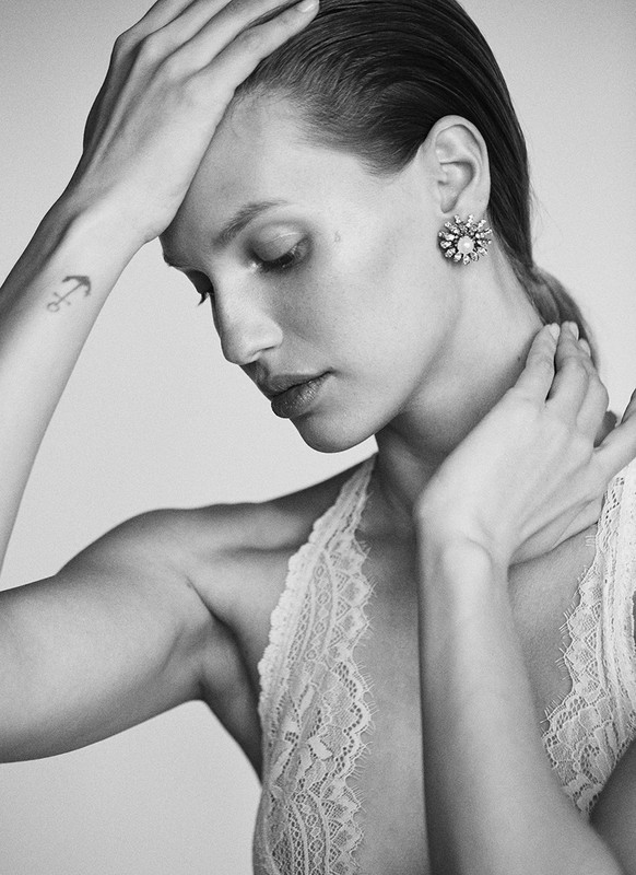 Close-up portrait of a woman wearing lace lingerie and a jeweled floral earring with make-up by Chichi Saito.