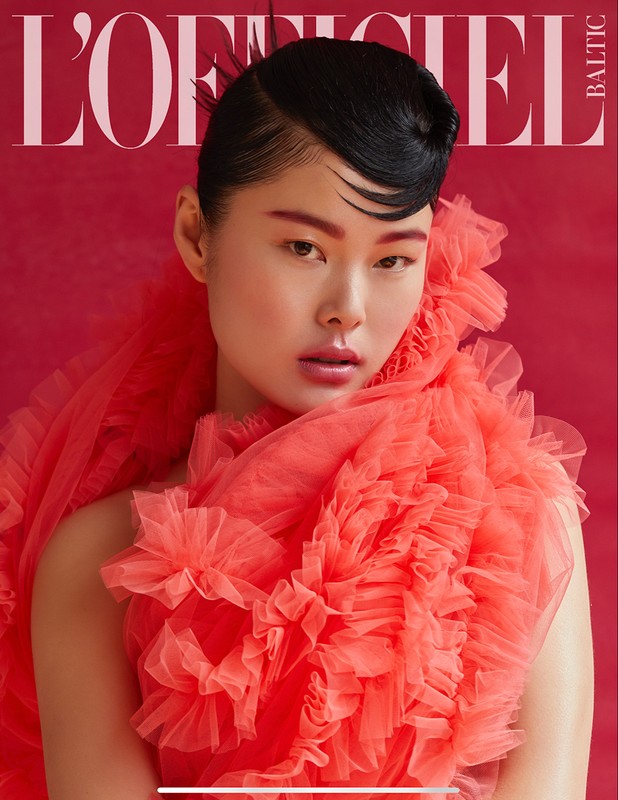 Magazine cover featuring a portrait of a woman with dark hair and red tulle ruffles against a red background with the magazine title visible.