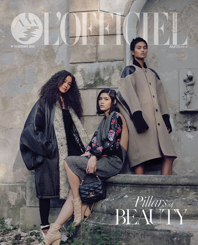 Fashion magazine cover features three Asian women in stylish outerwear, posed outdoors near stone pillars, showcasing modern editorial aesthetic.