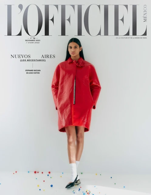 Fashion editorial cover with a woman in a red vinyl coat, white socks, and black heels standing in a white studio with colorful confetti.
