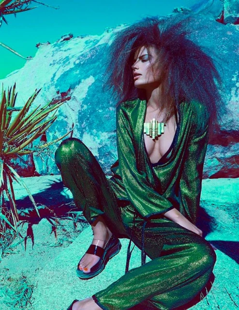 A fashion shot features an adult woman in a green outfit with a metallic necklace, posing outdoors on rocks in a sunny, desert-like landscape.