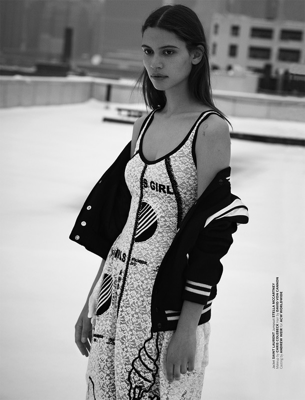 Black and white portrait of a model wearing a patterned dress and a dark jacket on a rooftop setting in Los Angeles.